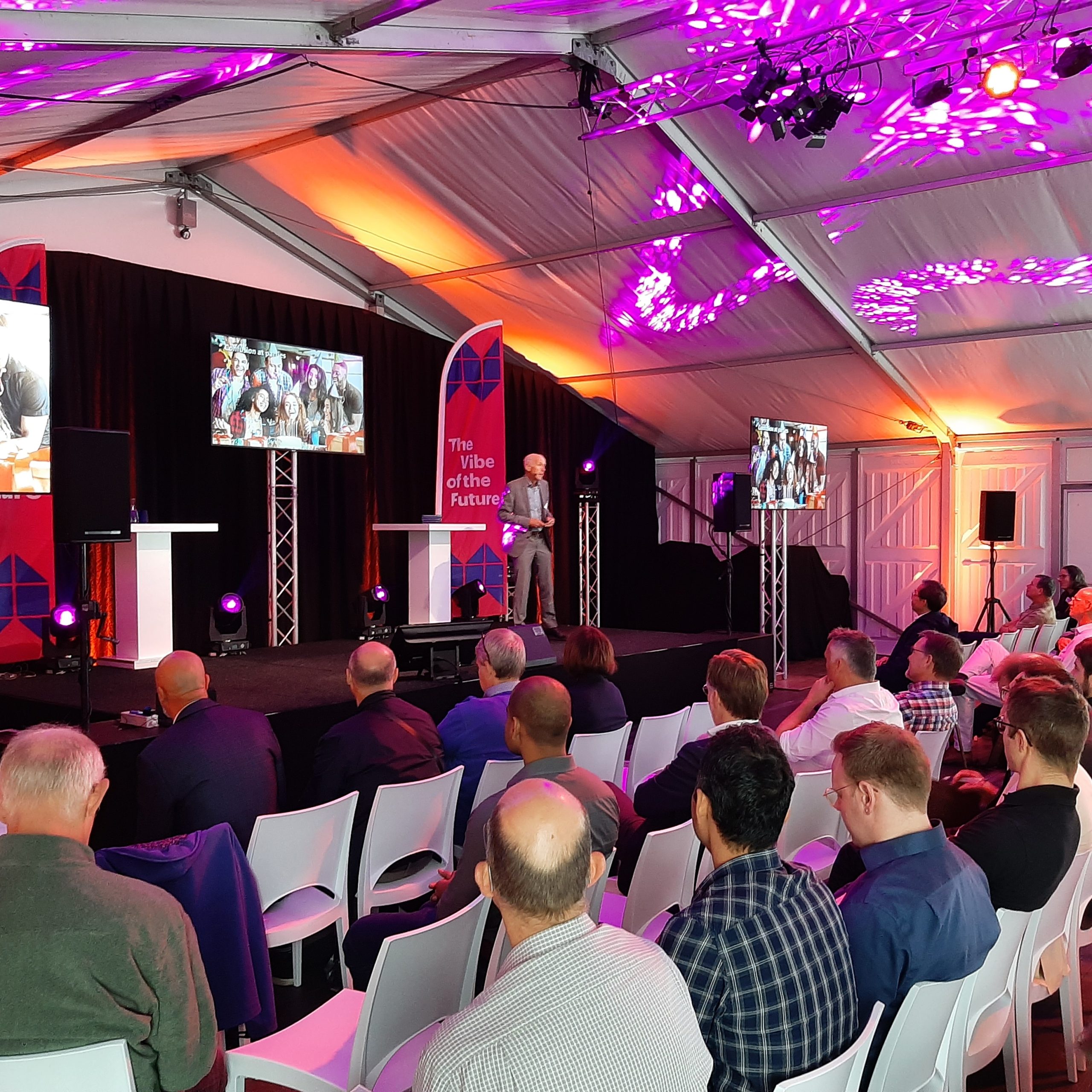 People listening to a speaker on a stage